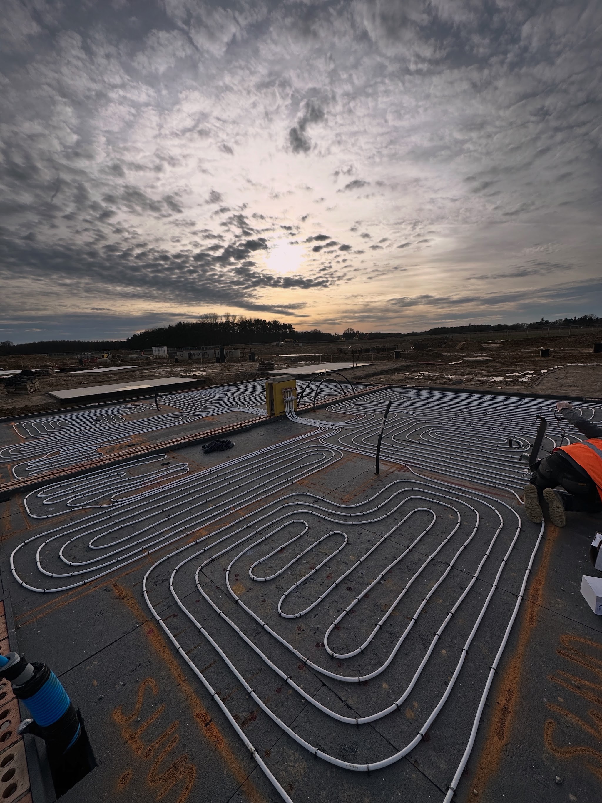 Heating pipe loops laid on a new-build floor slab at sunrise