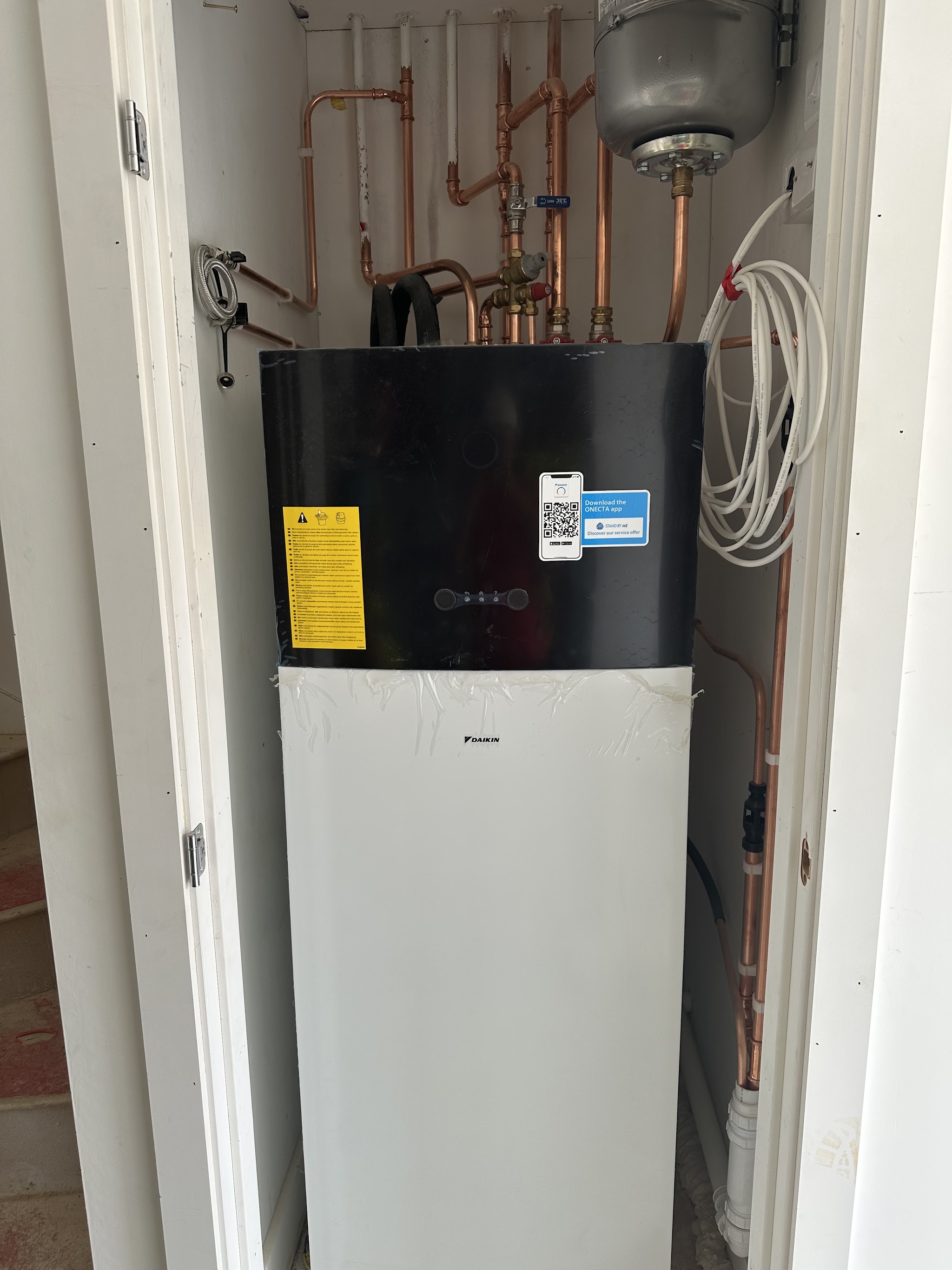 Daikin all-in-one heat pump cylinder unit installed in a cupboard